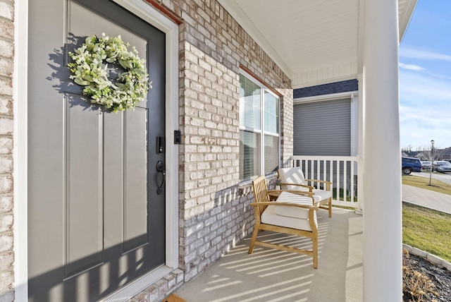 property entrance featuring brick siding and covered porch