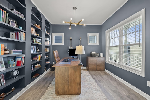 home office featuring crown molding, light wood-style flooring, a notable chandelier, and baseboards