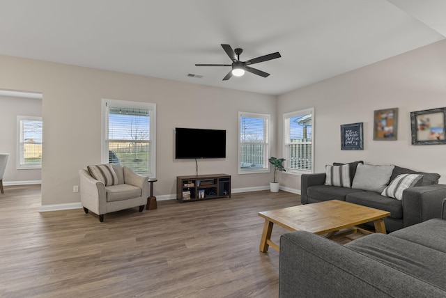 living area with ceiling fan, visible vents, baseboards, and wood finished floors