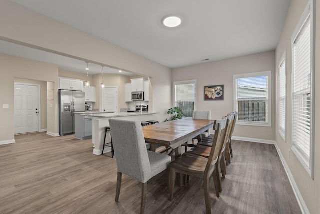 dining area with baseboards and light wood-style floors