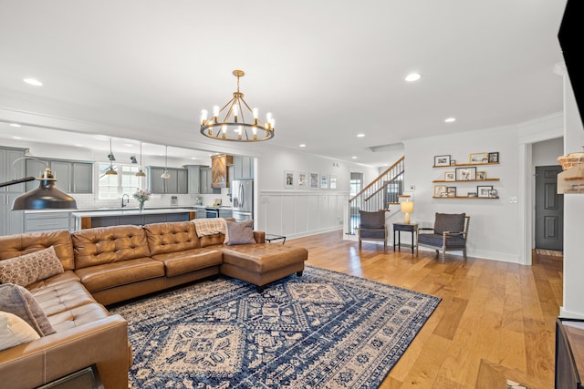 living room with light wood finished floors, stairway, recessed lighting, and crown molding