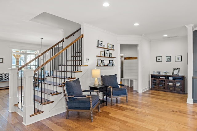 interior space with light wood-type flooring, ornamental molding, and stairs