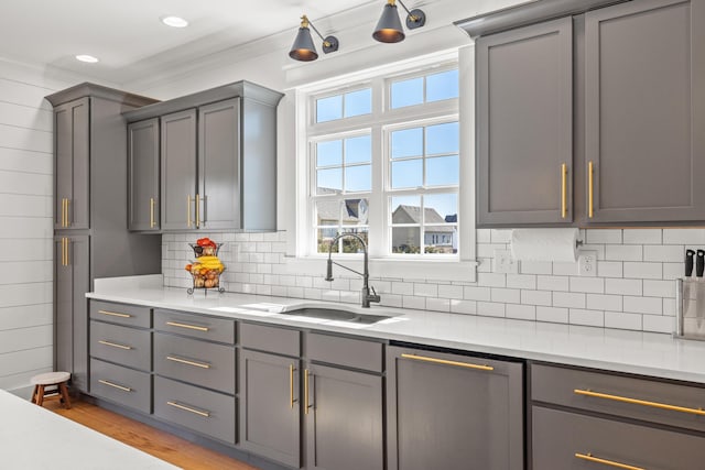 kitchen with a sink, decorative backsplash, and light countertops