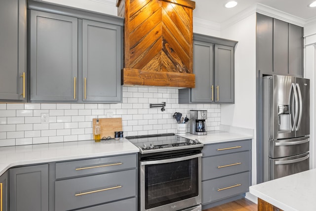 kitchen with decorative backsplash, appliances with stainless steel finishes, ornamental molding, and gray cabinetry