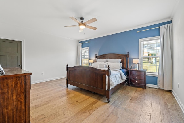 bedroom featuring light wood-type flooring, multiple windows, and ornamental molding