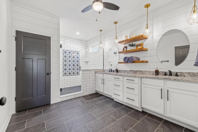 bathroom featuring a walk in shower, double vanity, recessed lighting, a ceiling fan, and a sink