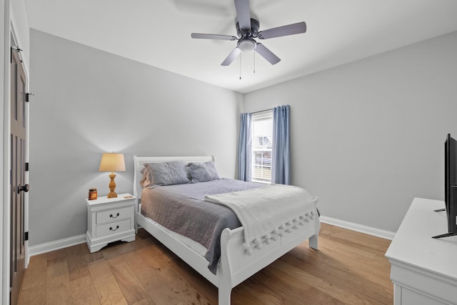 bedroom with baseboards, light wood-style floors, and a ceiling fan