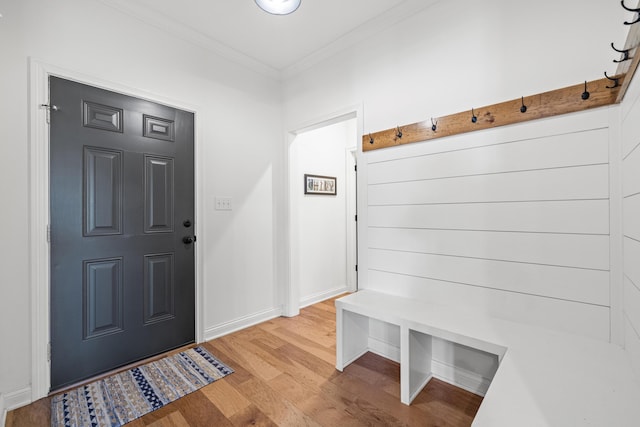 mudroom with light wood-type flooring, baseboards, and ornamental molding