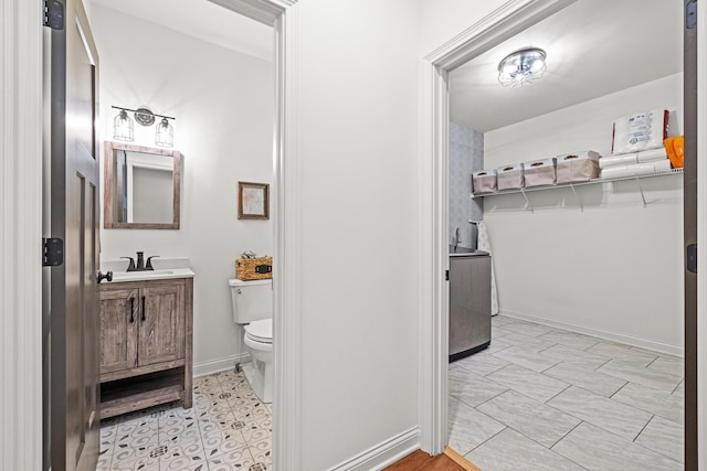 bathroom featuring vanity, toilet, and baseboards