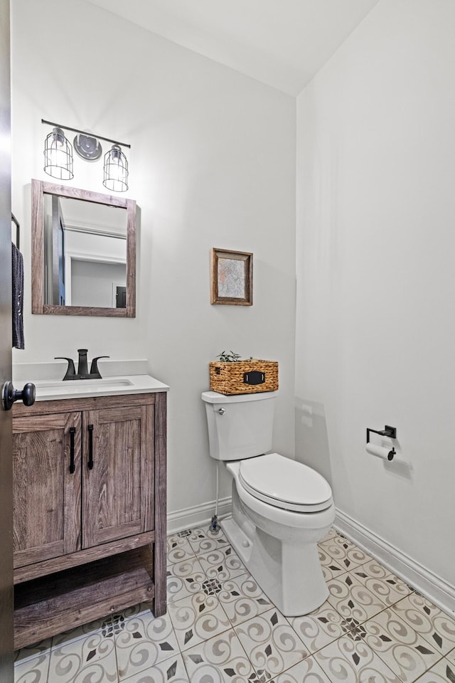 bathroom with tile patterned floors, baseboards, toilet, and vanity