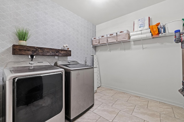 clothes washing area featuring wallpapered walls, laundry area, baseboards, and independent washer and dryer