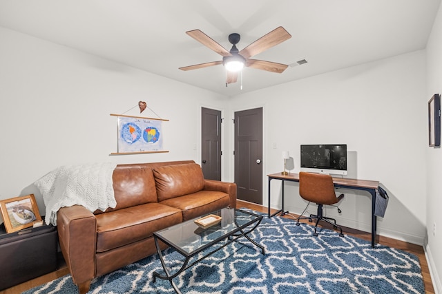 office space with visible vents, a ceiling fan, baseboards, and wood finished floors