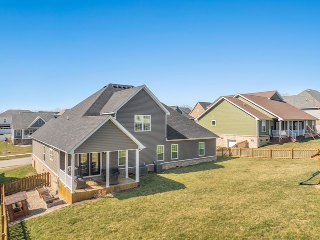 back of property with central AC unit, a yard, a fenced backyard, and a shingled roof