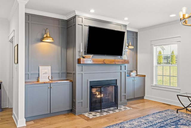 living room featuring a fireplace with flush hearth, recessed lighting, light wood finished floors, and ornamental molding