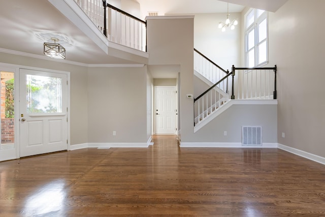 foyer featuring a notable chandelier, wood finished floors, visible vents, and a wealth of natural light