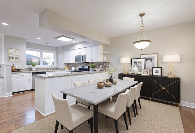 dining space with recessed lighting, baseboards, and wood finished floors