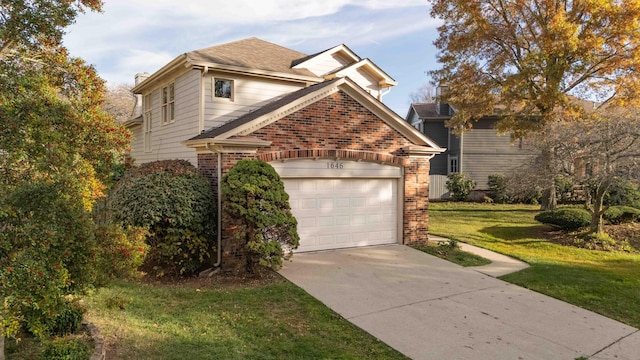 traditional-style house with a garage, driveway, brick siding, and a front yard