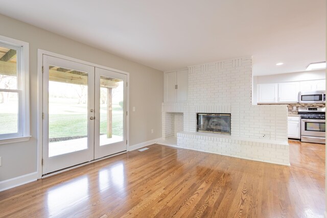 foyer featuring visible vents, plenty of natural light, baseboards, and wood finished floors