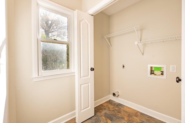 laundry area featuring electric dryer hookup, stone finish flooring, baseboards, hookup for a washing machine, and laundry area