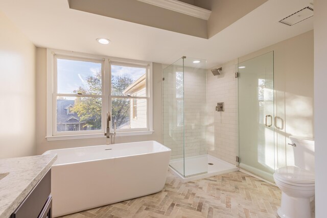 bathroom with visible vents, a shower stall, a freestanding bath, toilet, and vanity