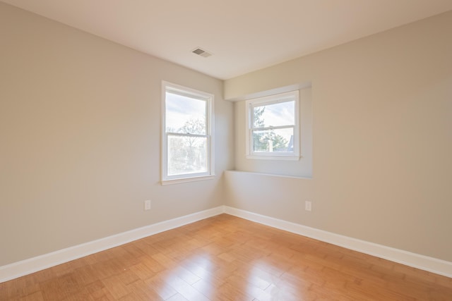 unfurnished room with light wood-type flooring, baseboards, and visible vents