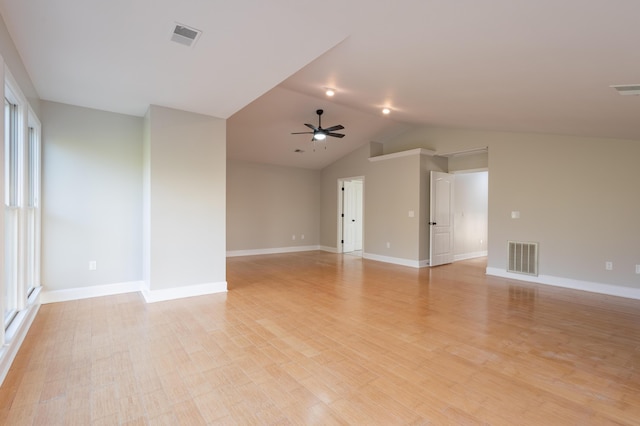 empty room featuring baseboards, visible vents, light wood finished floors, lofted ceiling, and ceiling fan