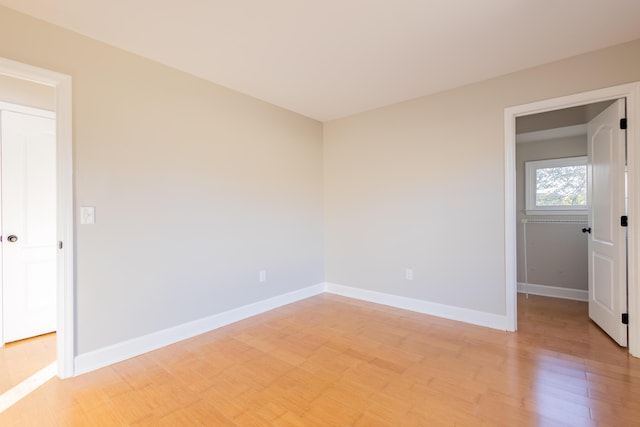 unfurnished room featuring light wood finished floors and baseboards
