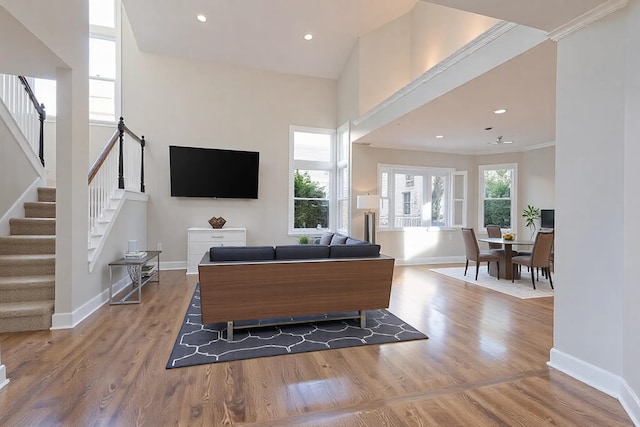 living area with stairway, baseboards, and wood finished floors