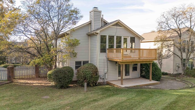 rear view of property with a yard, a patio, a chimney, and fence