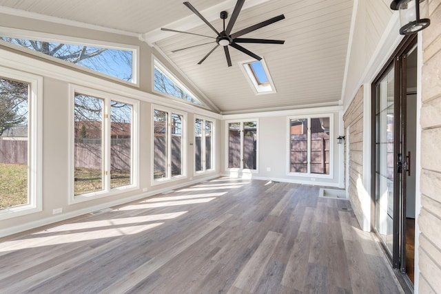 unfurnished sunroom with visible vents, vaulted ceiling with skylight, a healthy amount of sunlight, and a ceiling fan