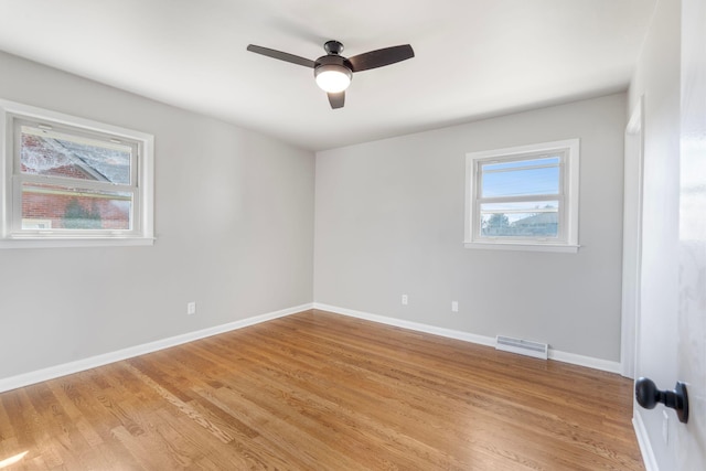 spare room featuring visible vents, baseboards, light wood-style flooring, and a ceiling fan