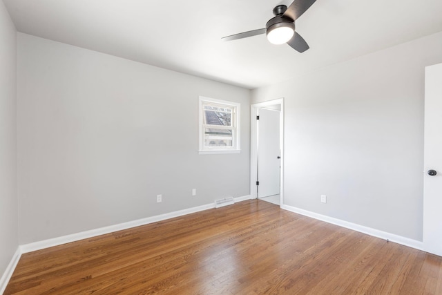 empty room featuring visible vents, ceiling fan, baseboards, and wood finished floors