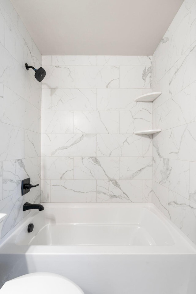 bathroom featuring bathtub / shower combination and toilet