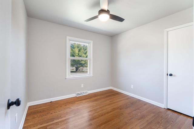 unfurnished room featuring visible vents, ceiling fan, baseboards, and wood finished floors