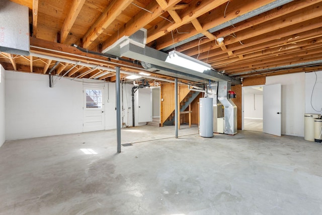 below grade area featuring stairs, heating unit, and water heater