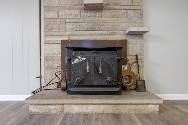 interior details featuring a wood stove and wood finished floors