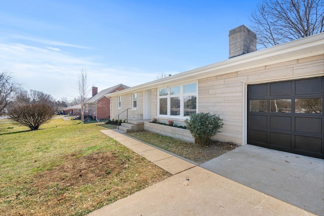 exterior space with a garage, a chimney, and a front lawn