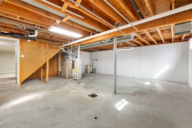 unfinished basement with gas water heater and heating unit