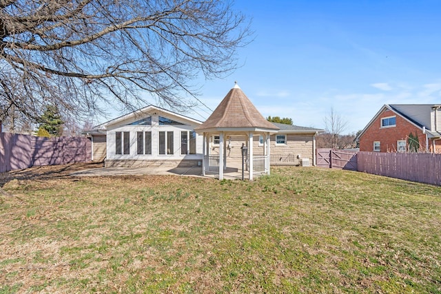 rear view of house with a yard, a patio, and a fenced backyard