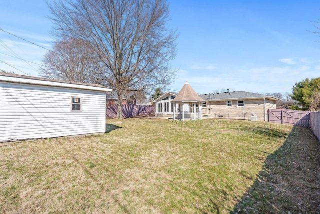 view of yard featuring a gazebo, an outbuilding, and a fenced backyard