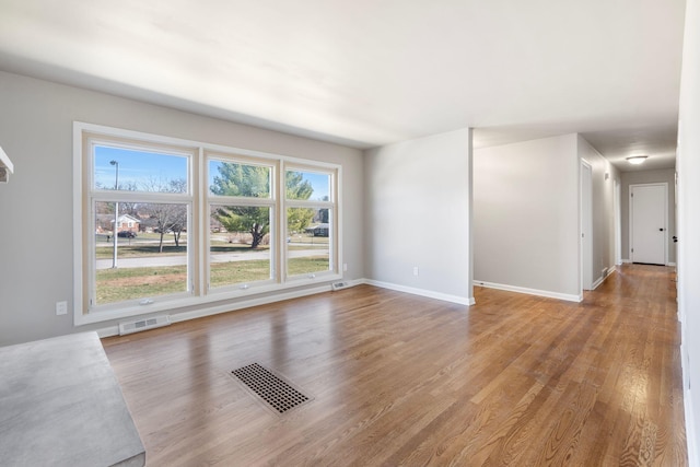 unfurnished living room with visible vents, baseboards, and light wood-style floors