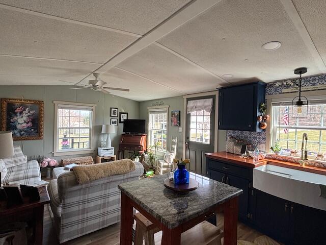 interior space featuring ceiling fan, lofted ceiling, a textured ceiling, and wood finished floors