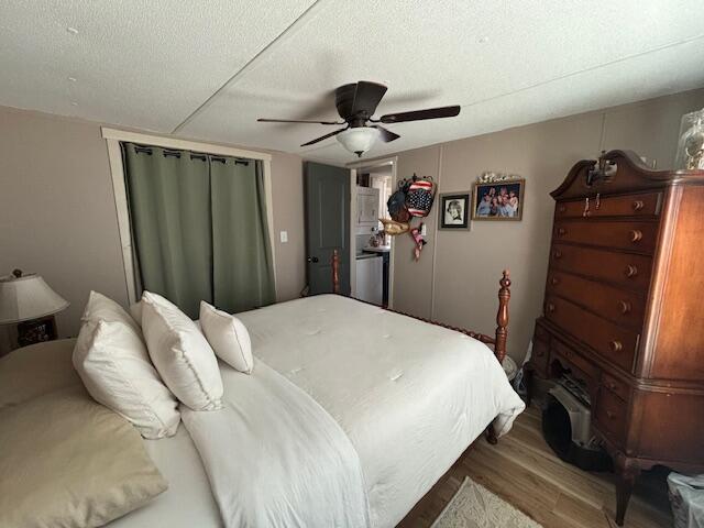 bedroom featuring a textured ceiling, ceiling fan, and wood finished floors