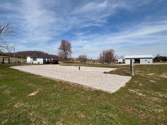 view of property's community with a lawn and an outdoor structure