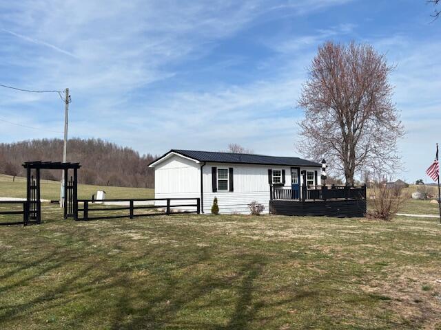 view of front of home featuring a front lawn, fence, and a wooden deck