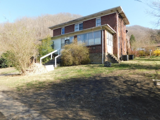 view of front of property with brick siding and central AC unit