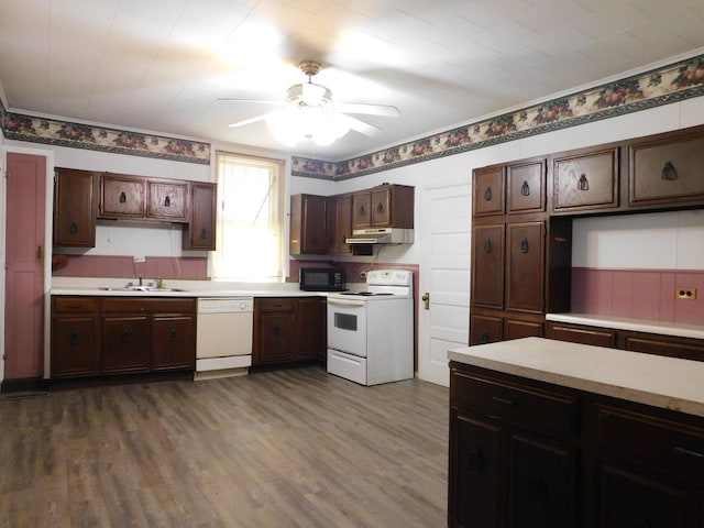 kitchen featuring white appliances, light countertops, and a sink