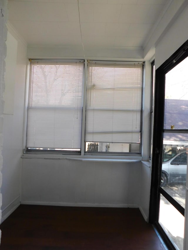 interior space featuring dark wood-style floors, baseboards, and ornamental molding