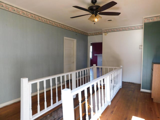 hall featuring visible vents, an upstairs landing, baseboards, and wood finished floors