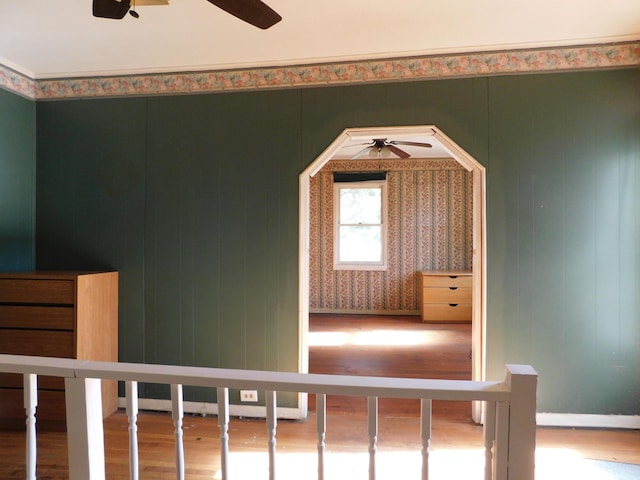 interior space featuring baseboards, ceiling fan, and wood finished floors